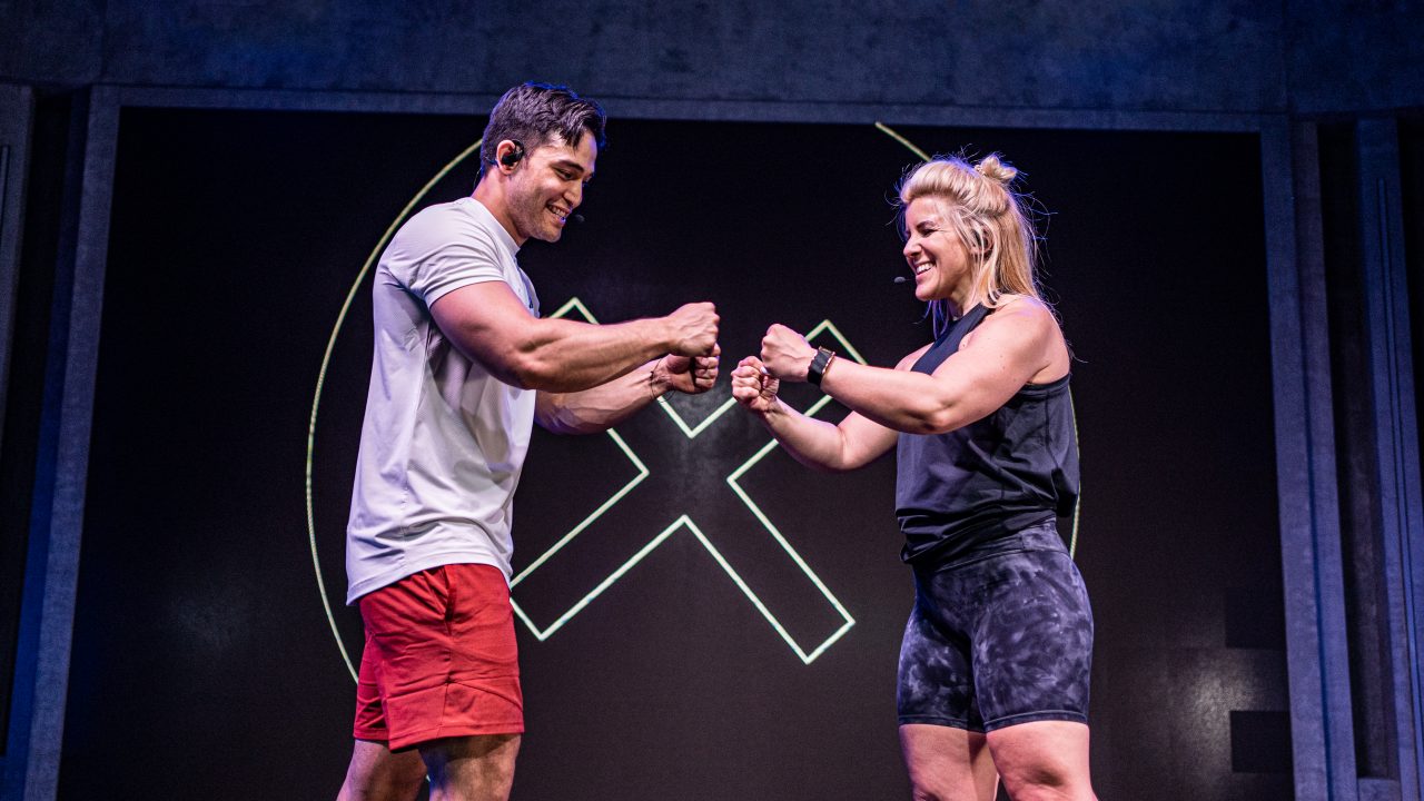 Fiit trainers Sean and Laura fist bumping after a workout