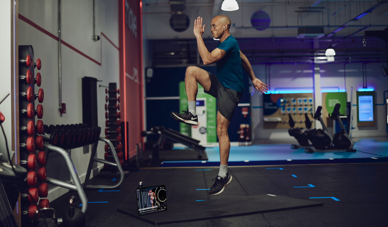 Man performing a bodyweight exercise in the gym using the Fiit app