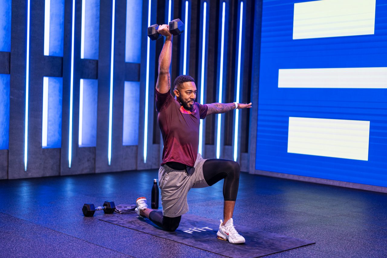 Fiit instructor Courtney Fearon demonstrating a kneeling single arm overhead press