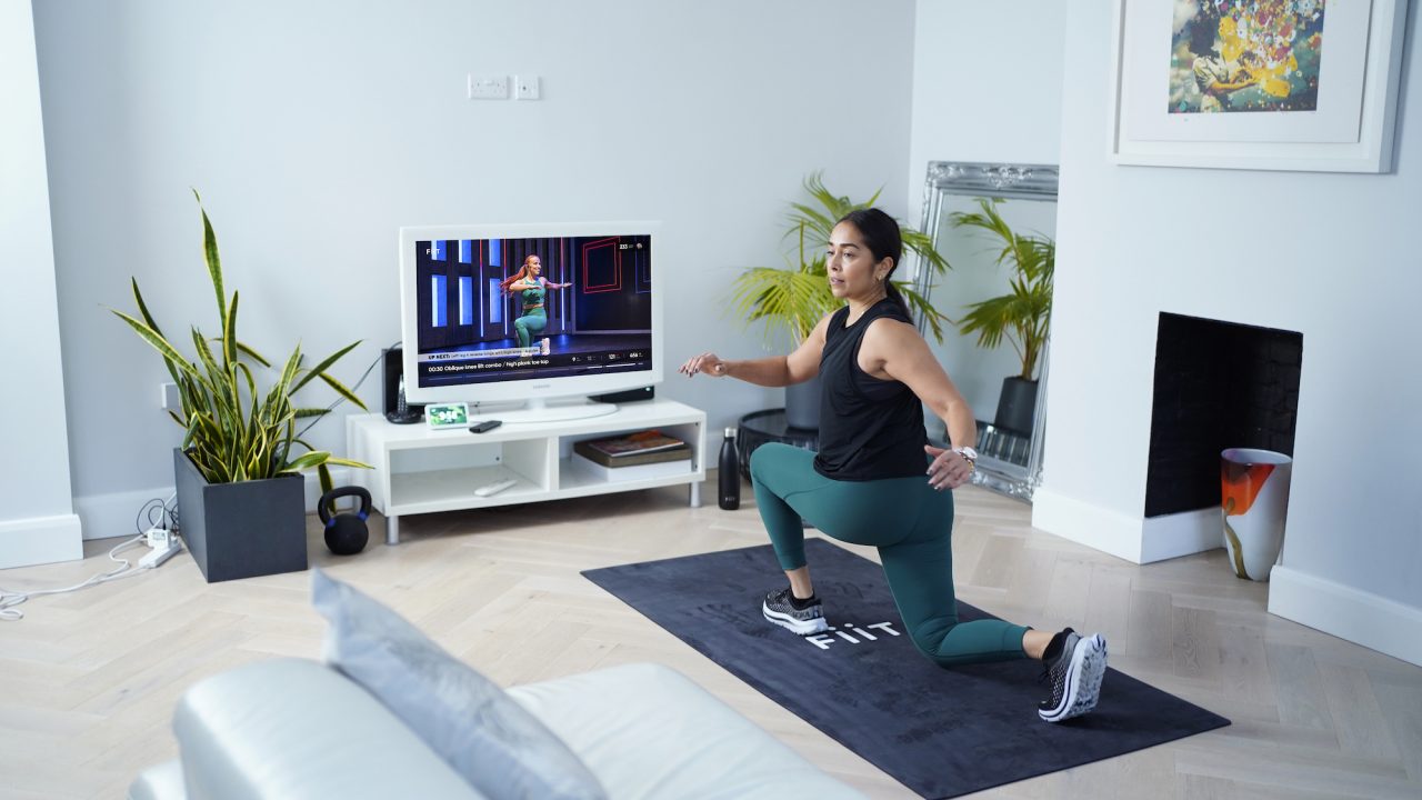 Woman performing a lunge during a home workout using Fiit - the UK's #1 rated fitness platform