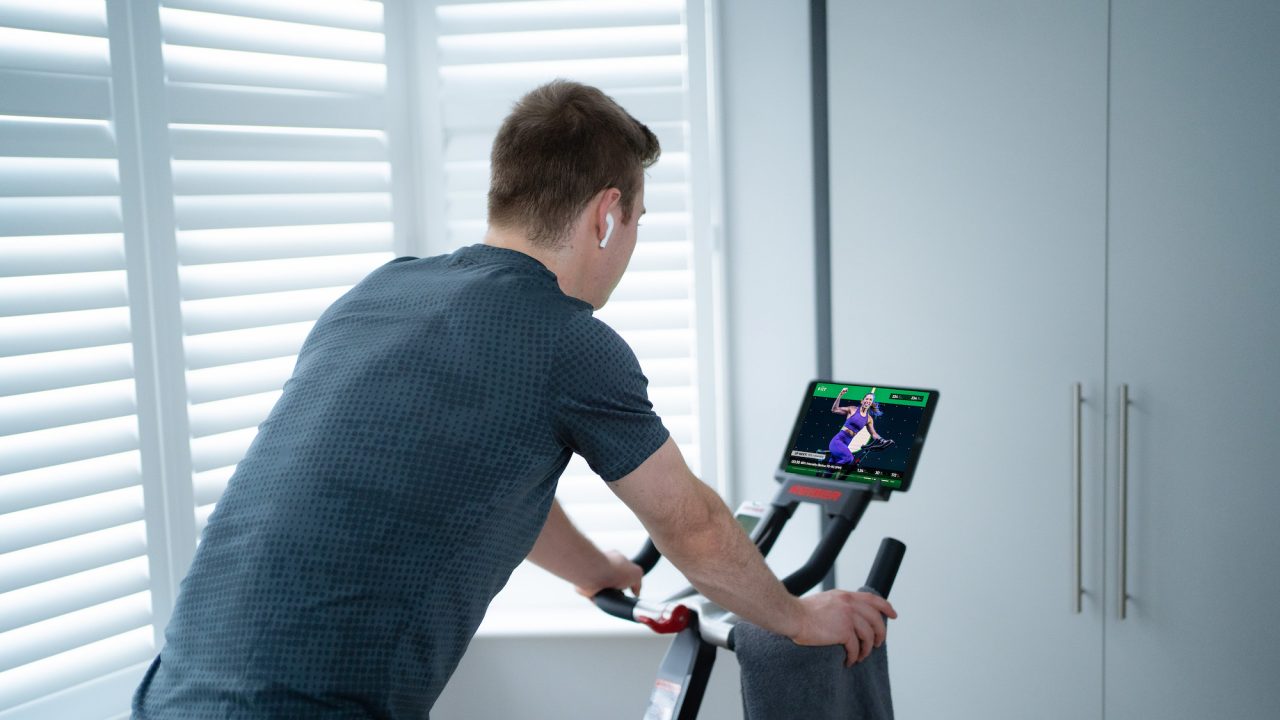 Man exercising on an indoor bike during a home workout using Fiit - the UK's #1 rated fitness platform