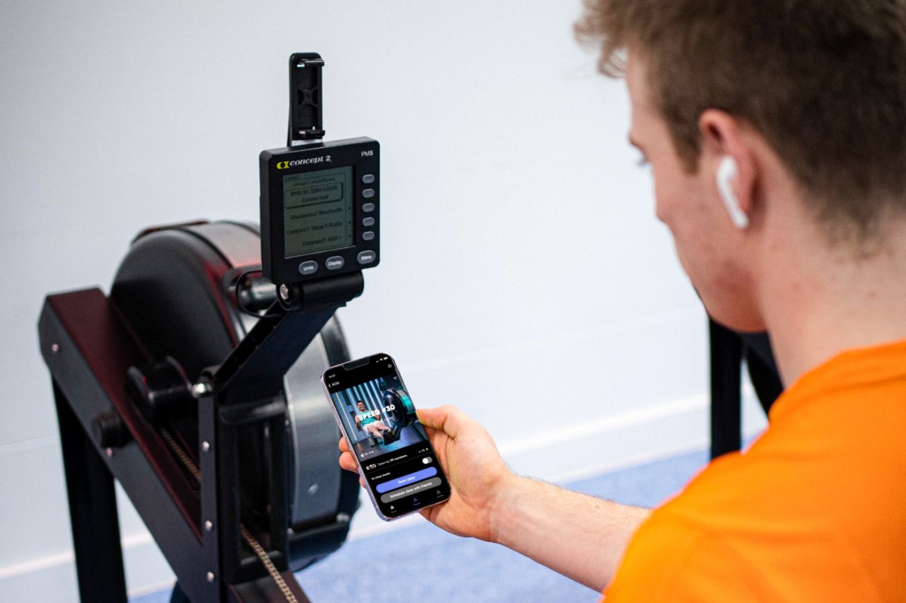 Man pairing his mobile with a rowing machine preparing to do a Fiit workout