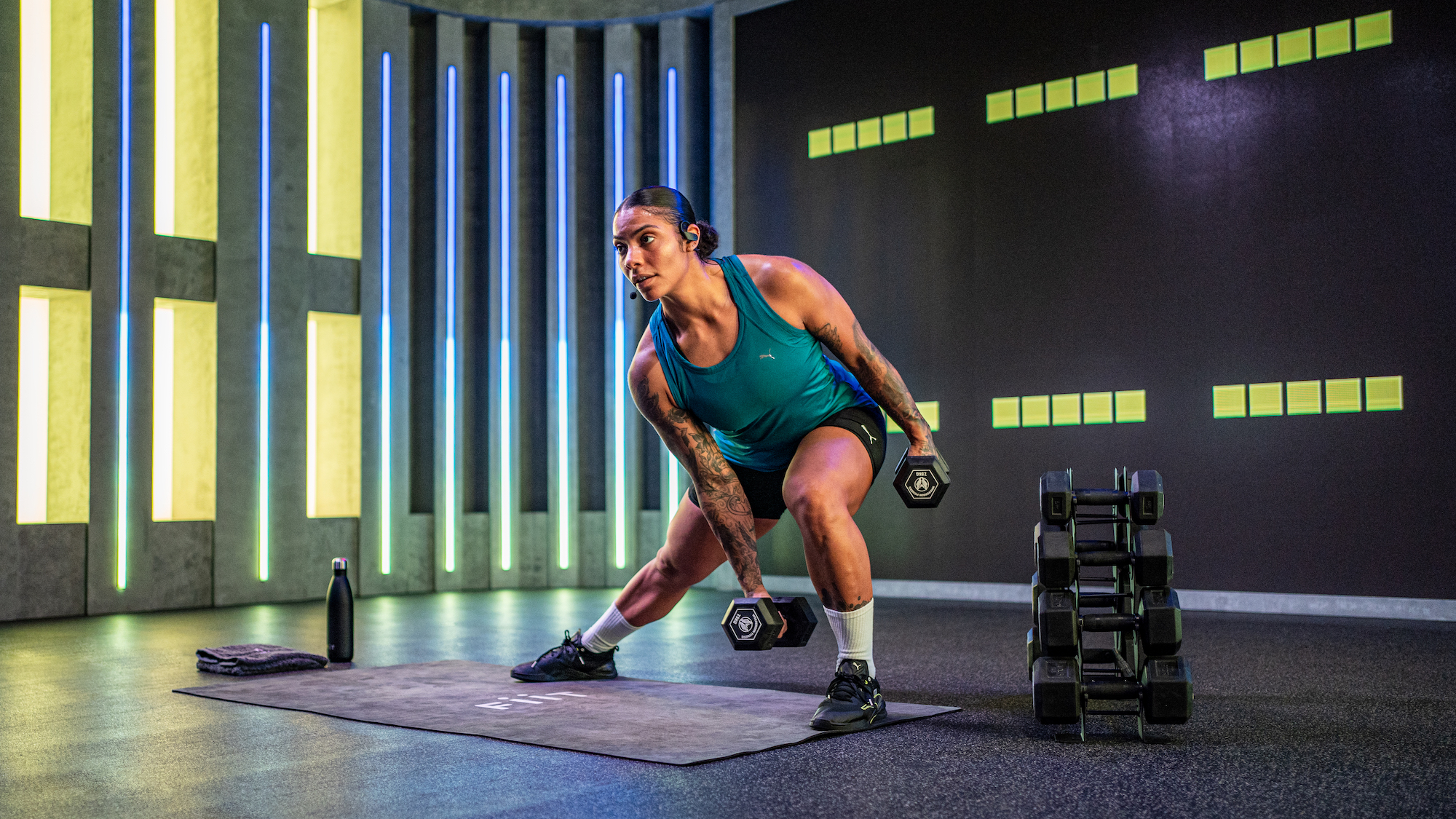 Fiit trainer and Olympic weightlifter Chloe Whylie demonstrating a side lunge with dumbbells