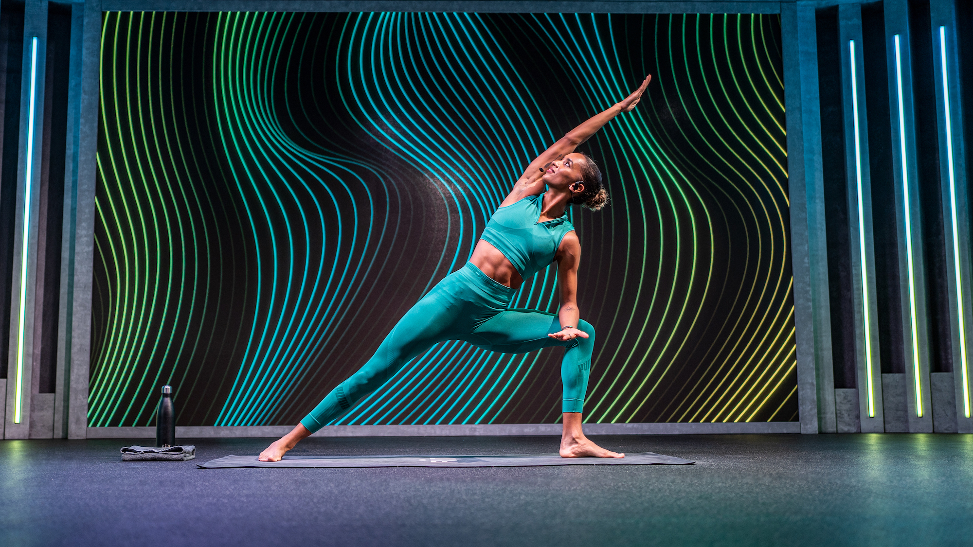 Fiit trainer and Olympic sprinter Lina Nielsen demonstrating a yoga side lunge with reach posture